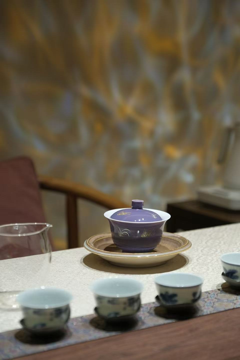 Purple gaiwan and cups arranged on a tea table